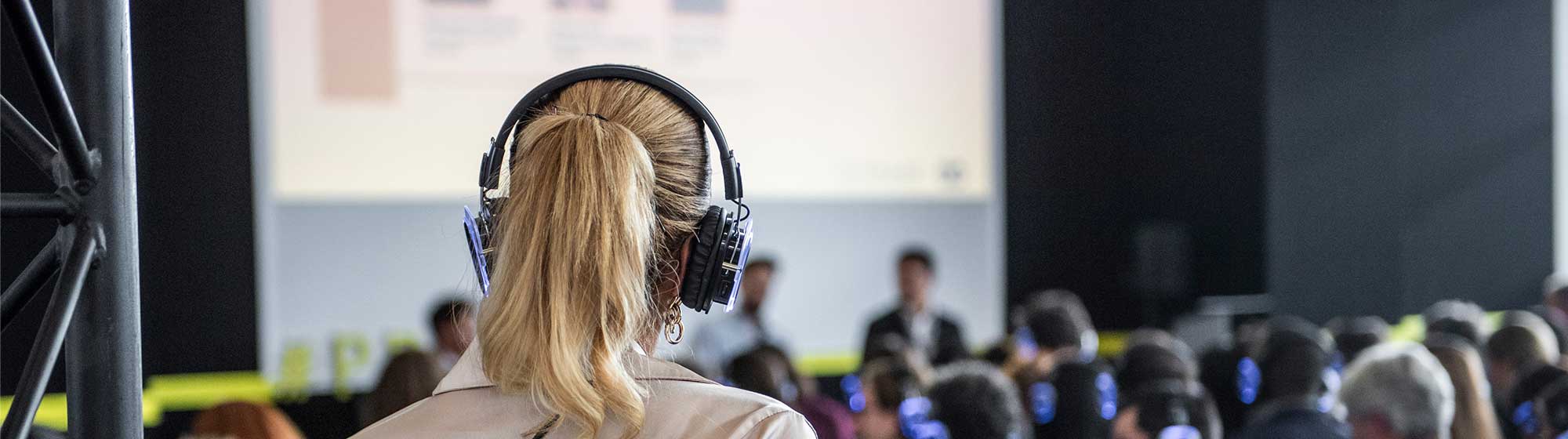 Woman with headphones listening to a podcast