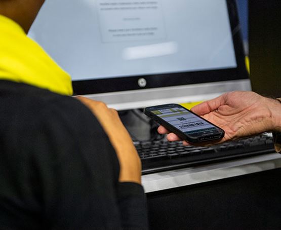 Visiteur montrant son billet sur son téléphone à un hôte