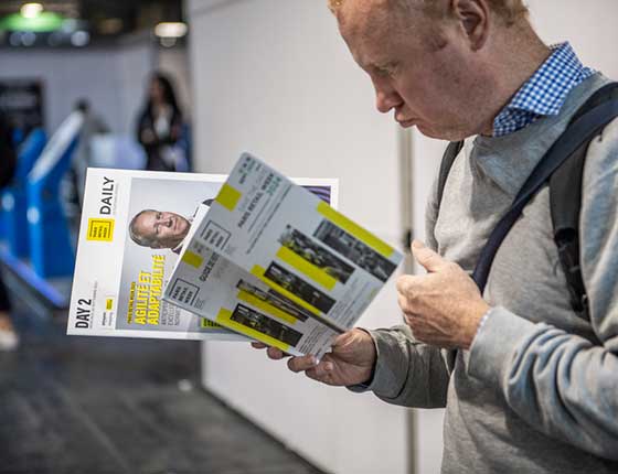 personne lisant un magazine du salon Paris retail Week